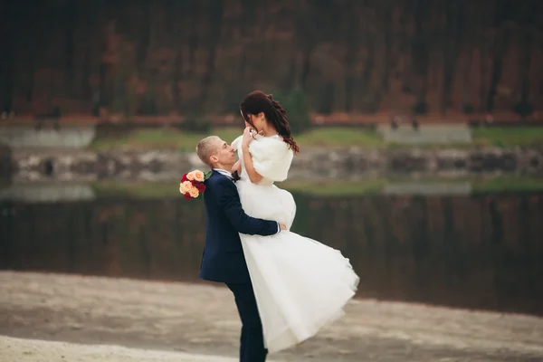 Amore e passione - bacio di coppia nuziale giovane sposata vicino a lago — Foto Stock