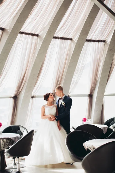 Glückliches Hochzeitspaar, Braut und Bräutigam posieren im Hotel — Stockfoto