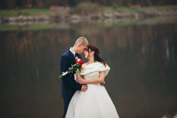 Kärlek och passion - kyss av gift unga brudparet nära lake — Stockfoto