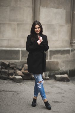 Güzel esmer genç kadın eski şehirde sokakta poz