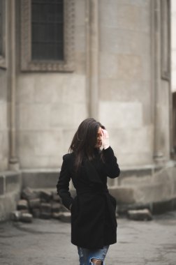 Güzel esmer genç kadın eski şehirde sokakta poz