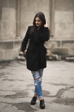 Güzel esmer genç kadın eski şehirde sokakta poz