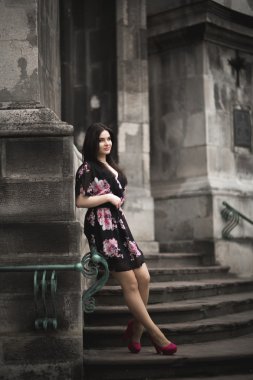 Güzel esmer genç kadın eski şehirde sokakta poz