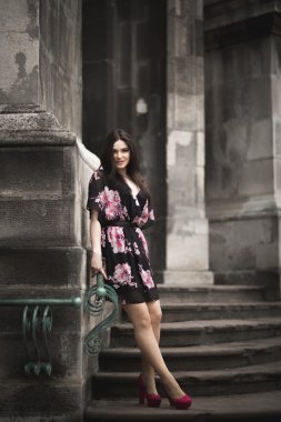 Güzel esmer genç kadın eski şehirde sokakta poz