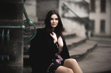 Güzel esmer genç kadın eski şehirde sokakta poz