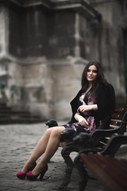 Güzel esmer genç kadın eski şehirde sokakta poz