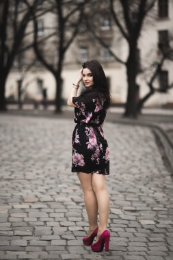 Güzel esmer genç kadın eski şehirde sokakta poz