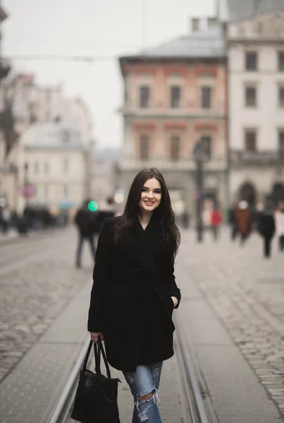 Vacker brunett ung kvinna poserar på gatan i gamla staden — Stockfoto