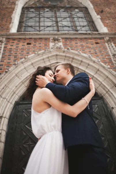 Gorgeous Bröllop par, bruden, brudgummen poserar nära gammal utfärda utegångsförbud för byggnad — Stockfoto