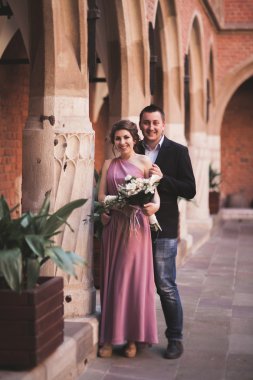 Genç çift aşk gelin ve damat ve arka plan üzerinde beyaz sütun içeren alan yakın poz. Krakow