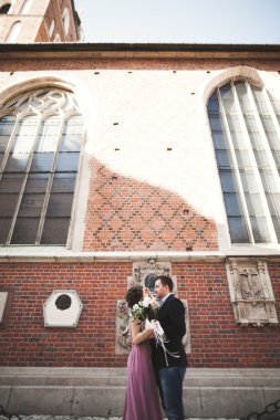 Yanında bir kilise poz zarif güzel düğün çifti. Krakow