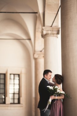 Mutlu düğün çift, damat, Gelin pembe elbise ile sarılma ve birbirlerine arka plan üzerinde gülümseyen duvarlar kalede