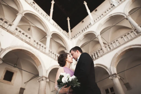 Boldog esküvői pár, vőlegény, menyasszony, rózsaszín ruha, átölelve hoznak, és mosolyogva egymást a háttérben a falak, a vár — Stock Fotó