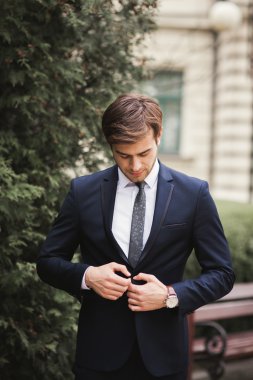 Genç şık işadamı ayarlama onun takım elbise, boyun kravat