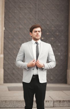 Genç şık işadamı ayarlama onun takım elbise, boyun kravat