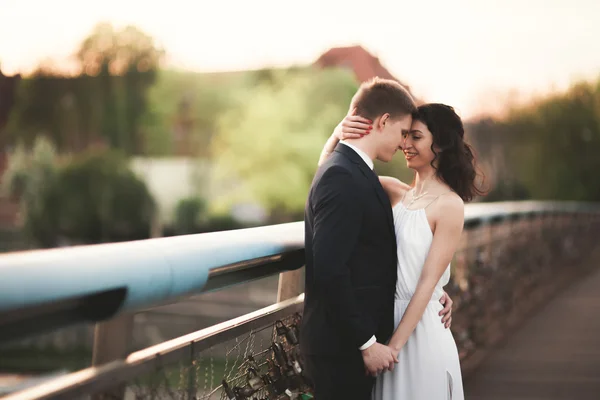 Gyönyörű esküvői pár, a menyasszony és a vőlegény pózol a híd Krakkóban — Stock Fotó