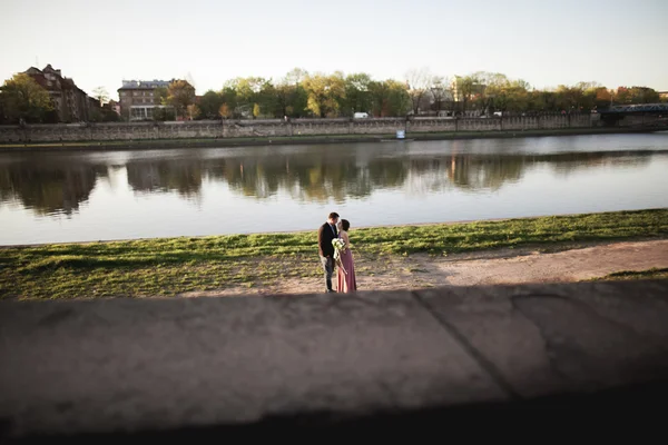 Hermosa pareja única entra en el día de su boda en Cracovia cerca del río Visla — Foto de Stock