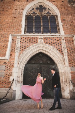 Muhteşem Düğün çifti, damat ve gelin pembe elbise Krakow eski şehirde yürüyüş ile