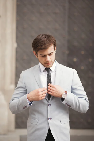 Joven hombre de negocios elegante ajustando su traje, corbata de cuello —  Fotos de Stock