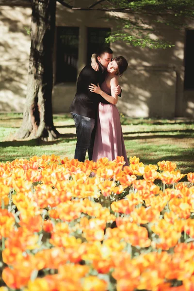 Casal jovem posando perto da árvore com flores — Fotografia de Stock