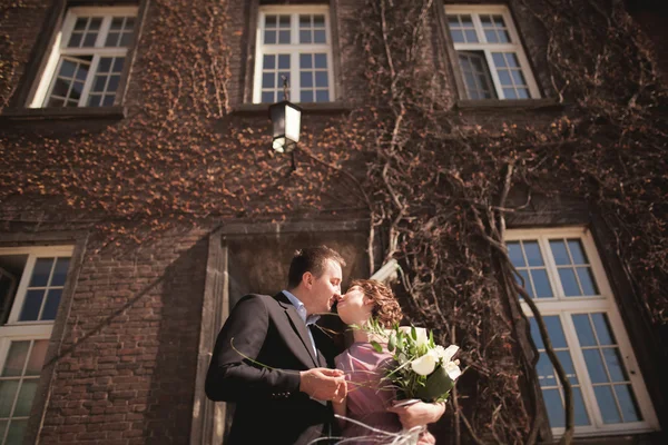 Pareja de boda joven en la historia de amor, novia y novio posando cerca de la construcción en el fondo. Cracovia —  Fotos de Stock