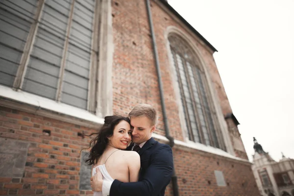 Splendida coppia di nozze, sposa, sposo posa vicino vecchio edificio cancello — Foto Stock