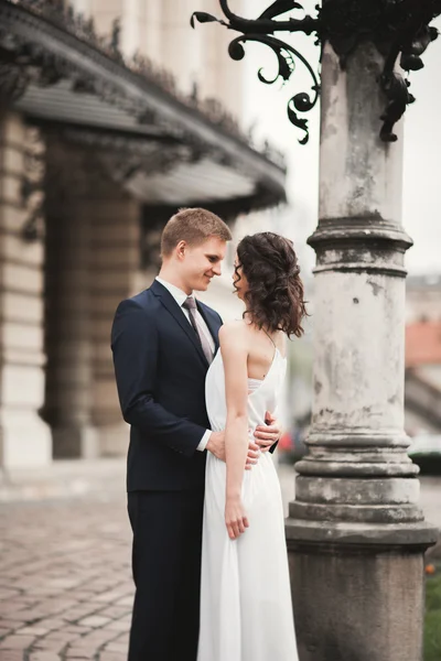 Beautiful bröllop par, bruden, brudgummen kyssas och kramas mot bakgrund av teater — Stockfoto