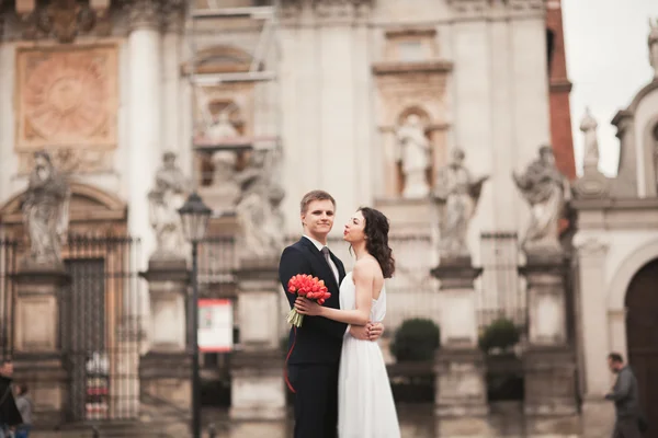 Bruid en bruidegom op de achtergrond van prachtige kerk. Prachtig oud gebouw. Arch. bruiloft — Stockfoto
