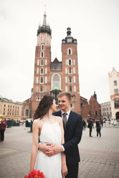 Elegante schöne Hochzeitspaar zu Fuß auf dem Hauptplatz in Krakau — Stockfoto