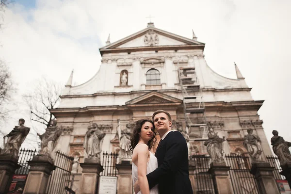 Bruid en bruidegom op de achtergrond van prachtige kerk. Prachtig oud gebouw. Arch. bruiloft — Stockfoto