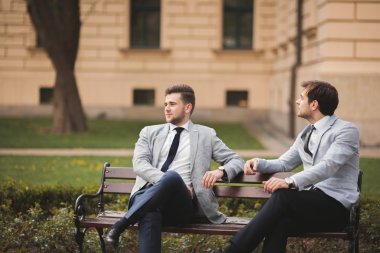 Konuşma ve açık havada gülümseyen iki şık iş adamları