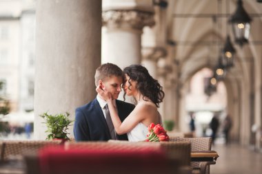 Çift, düğün, gülümseyen ve öpüşme kafede oturan kız