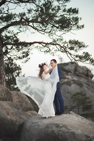 Splendido matrimonio coppia baci e abbracci vicino alle scogliere con vista mozzafiato — Foto Stock