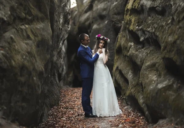 Wunderschöne Hochzeitspaar küsst und umarmt sich in der Nähe der Klippen mit atemberaubender Aussicht — Stockfoto