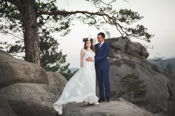 Splendido matrimonio coppia baci e abbracci vicino alle scogliere con vista mozzafiato — Foto Stock