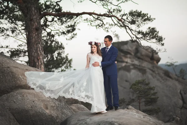 Splendido matrimonio coppia baci e abbracci vicino alle scogliere con vista mozzafiato — Foto Stock