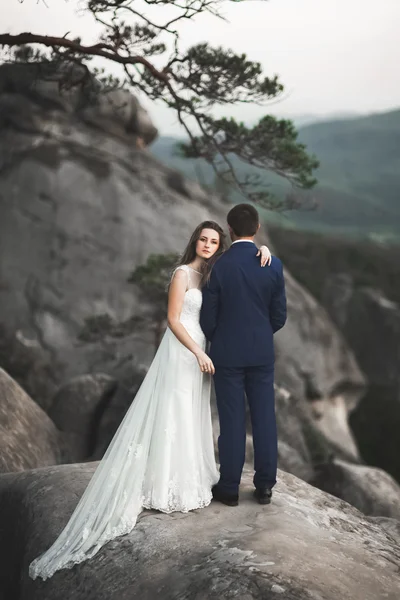 Splendido matrimonio coppia baci e abbracci vicino alle scogliere con vista mozzafiato — Foto Stock