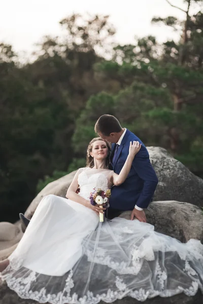 Hermosa pareja de boda besándose y abrazándose cerca de los acantilados con impresionantes vistas — Foto de Stock