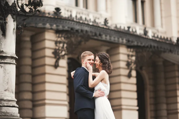 Beau couple de mariage, mariée, marié baisers et câlins sur fond de théâtre — Photo