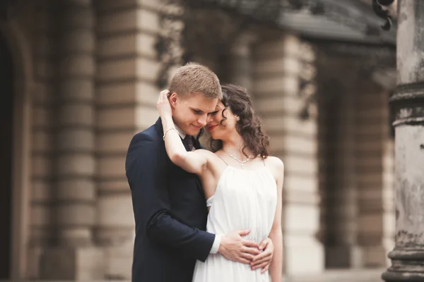 Krásná Svatební pár, nevěsta, ženich, líbání a objímání na pozadí divadlo — Stock fotografie