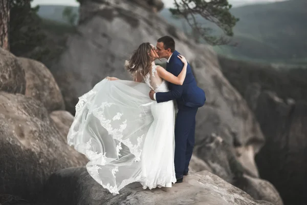 Splendido matrimonio coppia baci e abbracci vicino alle scogliere con vista mozzafiato — Foto Stock