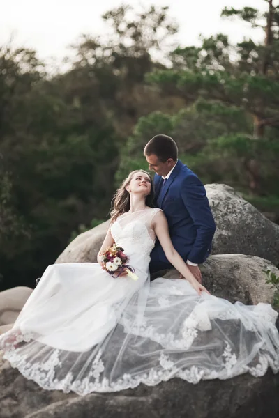 Hermosa pareja de boda besándose y abrazándose cerca de los acantilados con impresionantes vistas —  Fotos de Stock