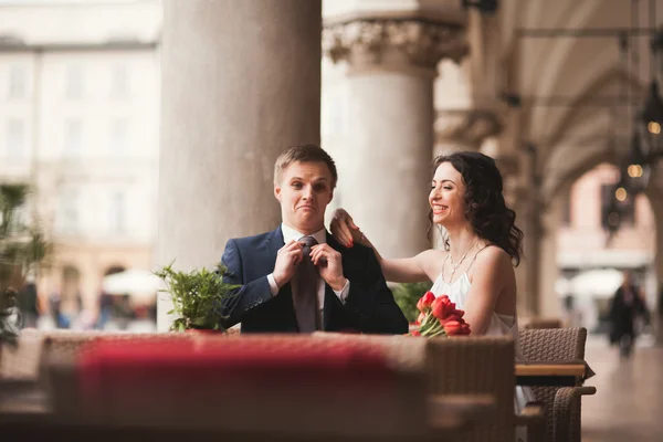 結婚式のカップルは、男は、笑みを浮かべて、キスのカフェで座っている女の子 — ストック写真