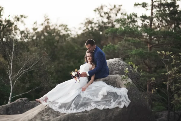 Hermosa pareja de boda besándose y abrazándose cerca de los acantilados con impresionantes vistas — Foto de Stock