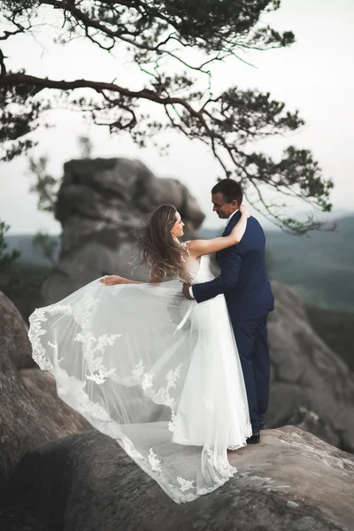 Splendido matrimonio coppia baci e abbracci vicino alle scogliere con vista mozzafiato — Foto Stock