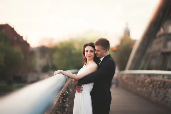 Hermosa pareja de novios posando en un puente en Cracovia — Foto de Stock