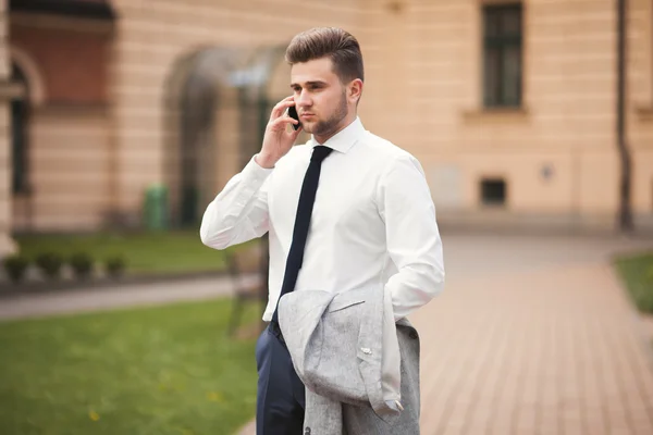 Elegante joven hombre de negocios hablando por teléfono al aire libre — Foto de Stock