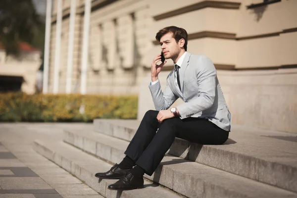 Elegante jovem empresário falando ao telefone ao ar livre — Fotografia de Stock