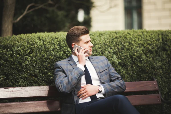 Elegante joven hombre de negocios hablando por teléfono al aire libre —  Fotos de Stock