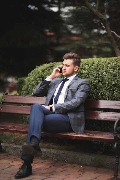 Elegante joven hombre de negocios hablando por teléfono al aire libre —  Fotos de Stock